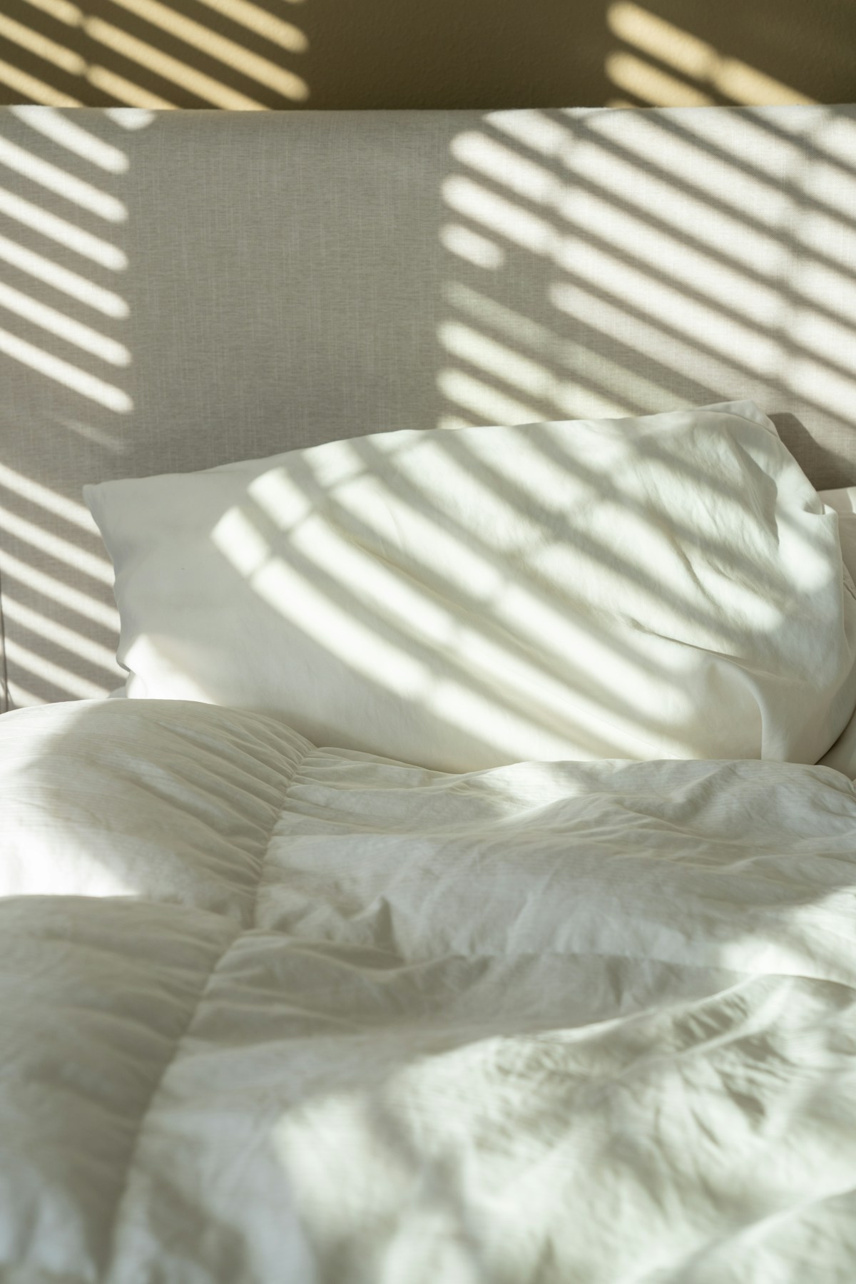 Fresh white pillows and soft bed linen in the morning sunlight