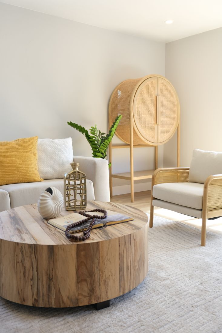 A bright, freshly cared-for living room with a soft sofa and natural textures